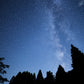 Night sky over Yame Hoshinomura — the Milky Way visible above the silhouetted mountain forest of the tea-growing village whose name (星の雫, 'Star Dewdrop') reflects this scene