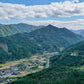 Aerial view of the Yame Hoshinomura tea-growing region — a small village in a mountain valley with rice paddies and forested slopes, in Fukuoka Prefecture