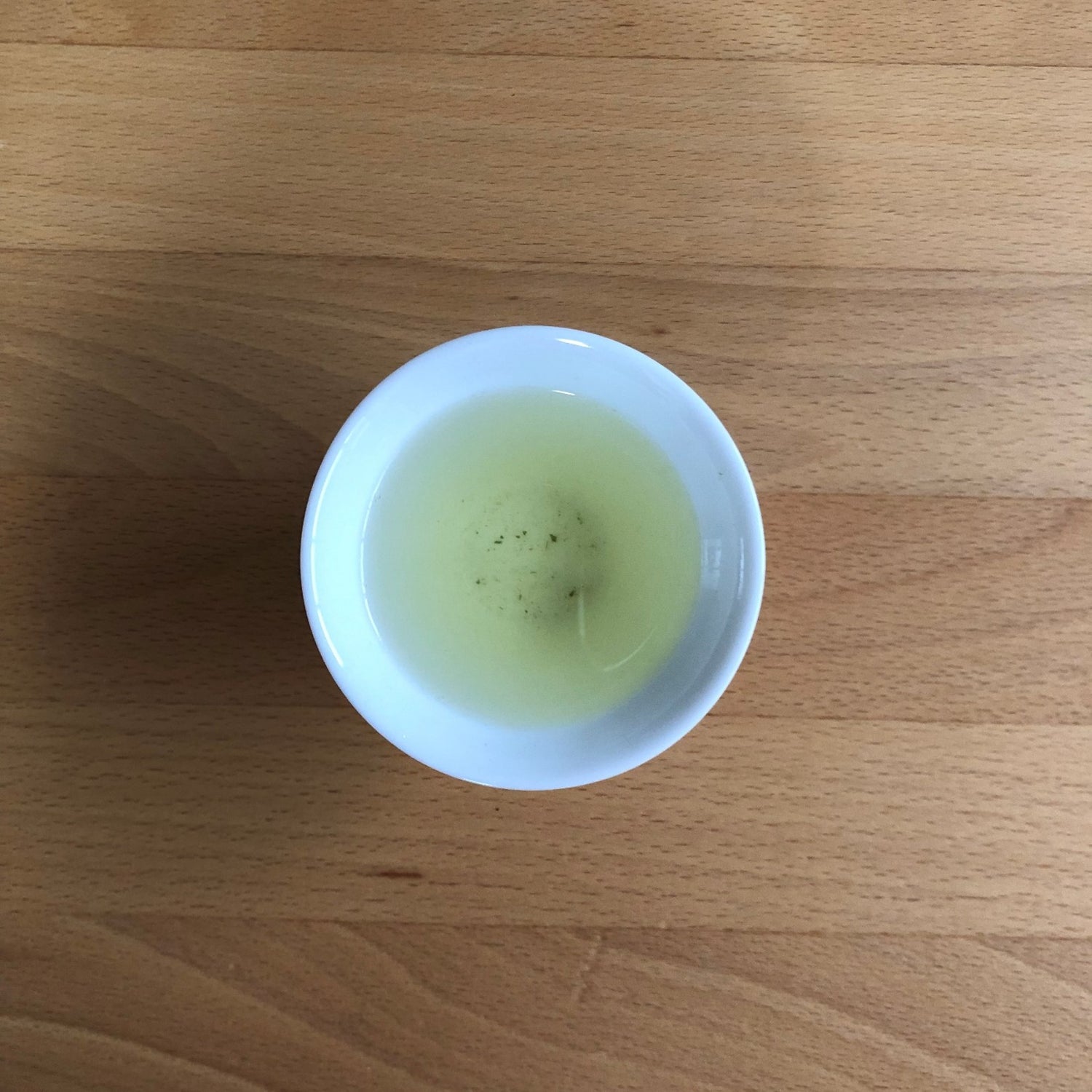 Hatsuzumi sencha brewed in a small Japanese cup, pale yellow-green liquor